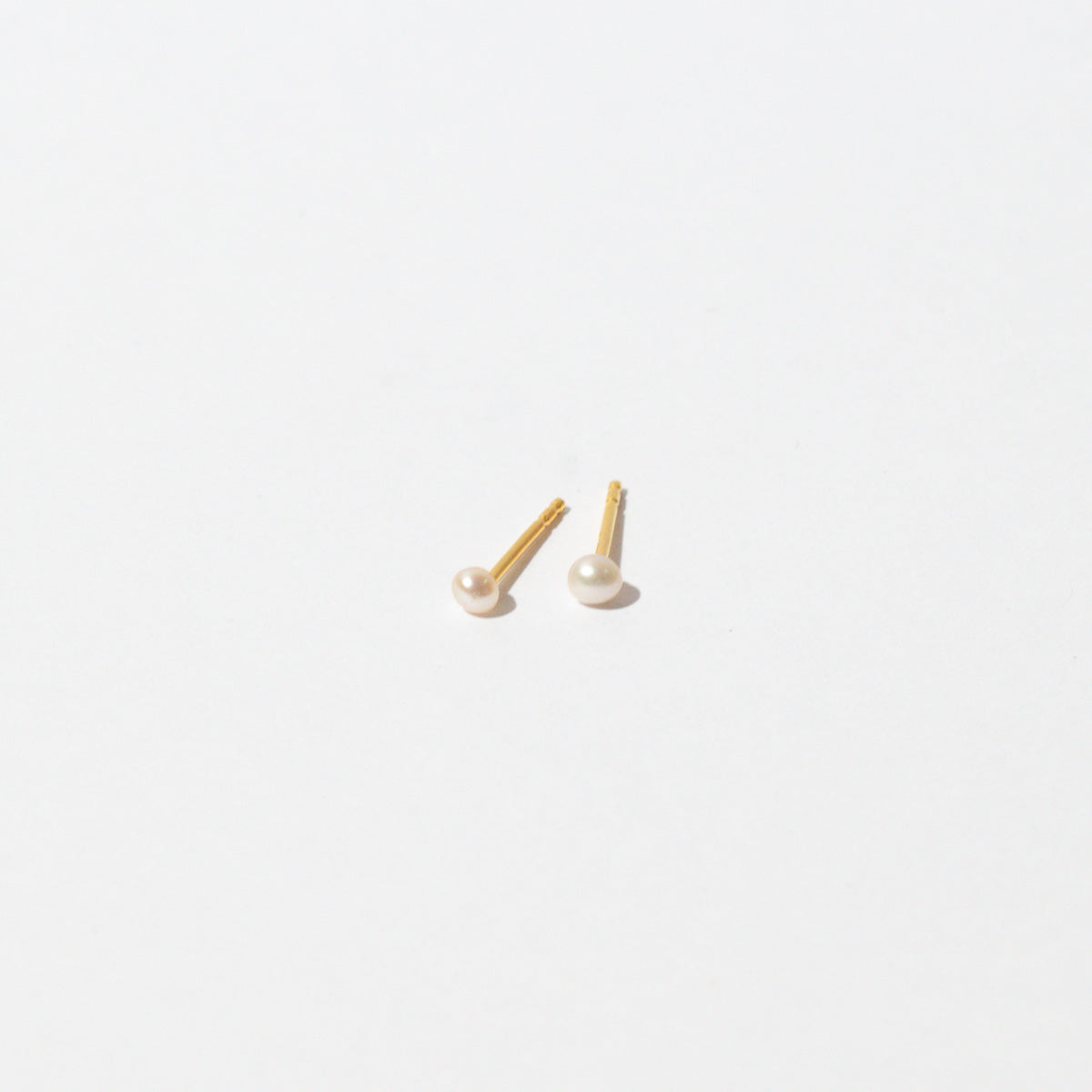 Radiant Pearl Stud Earrings in Gold flat lay