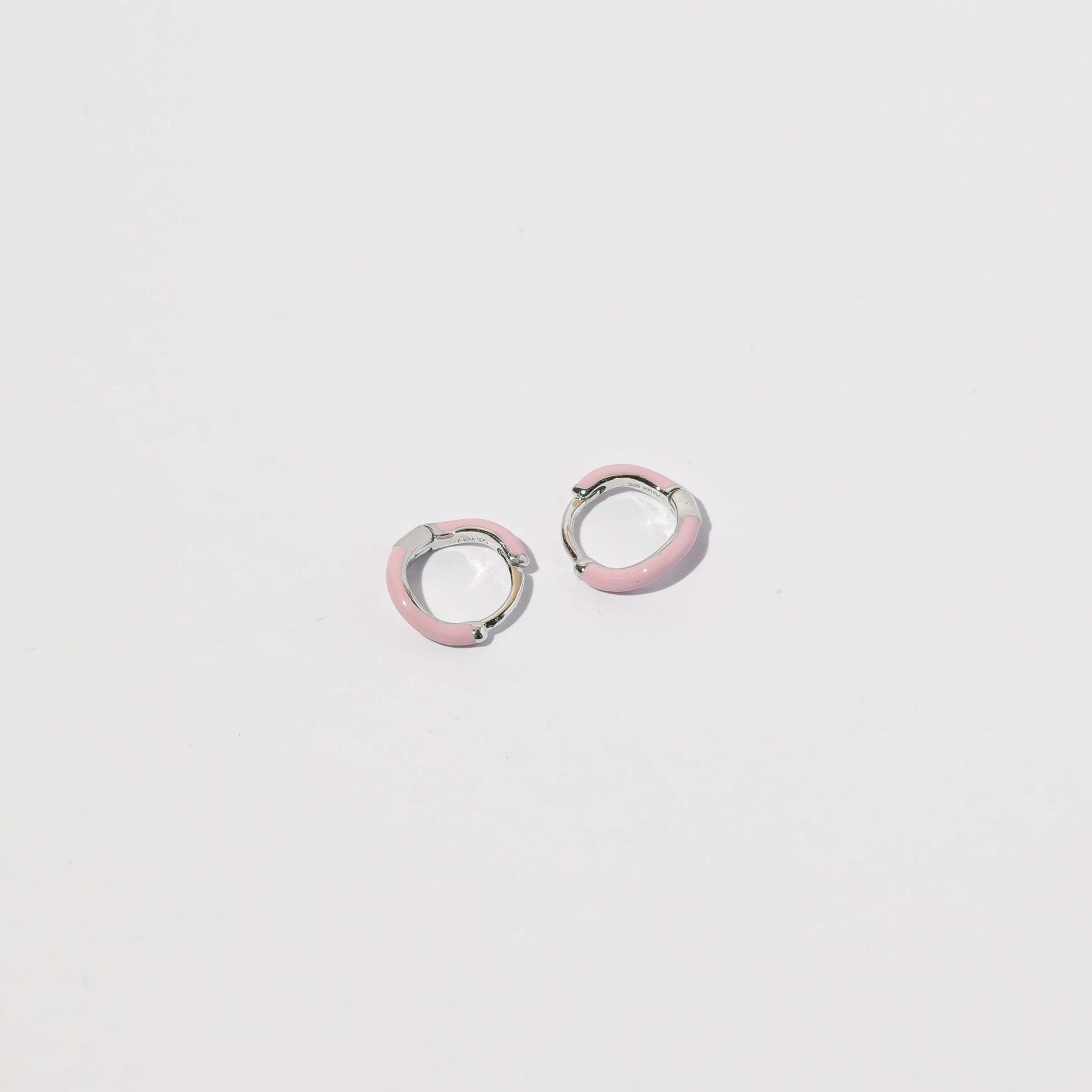 Wave Pink Enamel Huggies in Silver flat lay