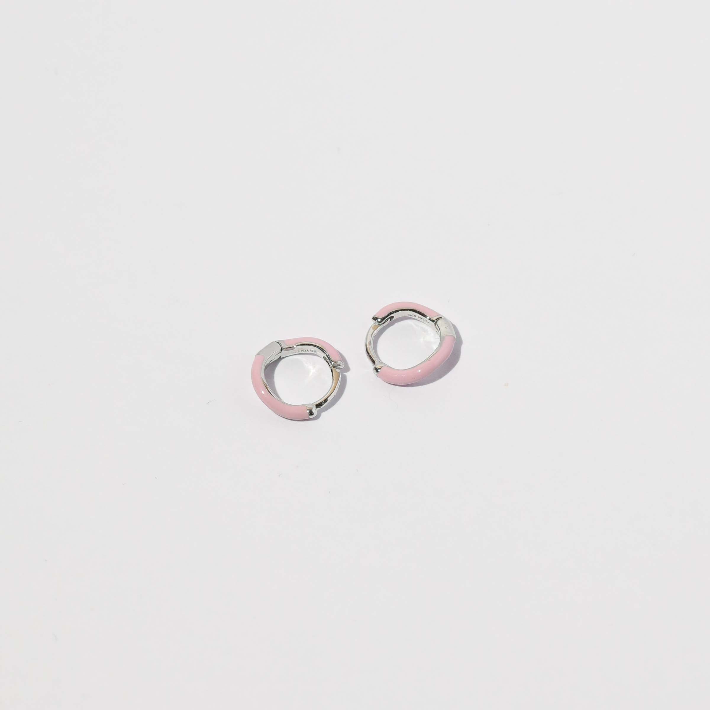 Wave Pink Enamel Huggies in Silver flat lay