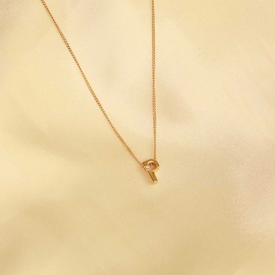 Flat lay shot of P Initial Pendant Necklace in Gold