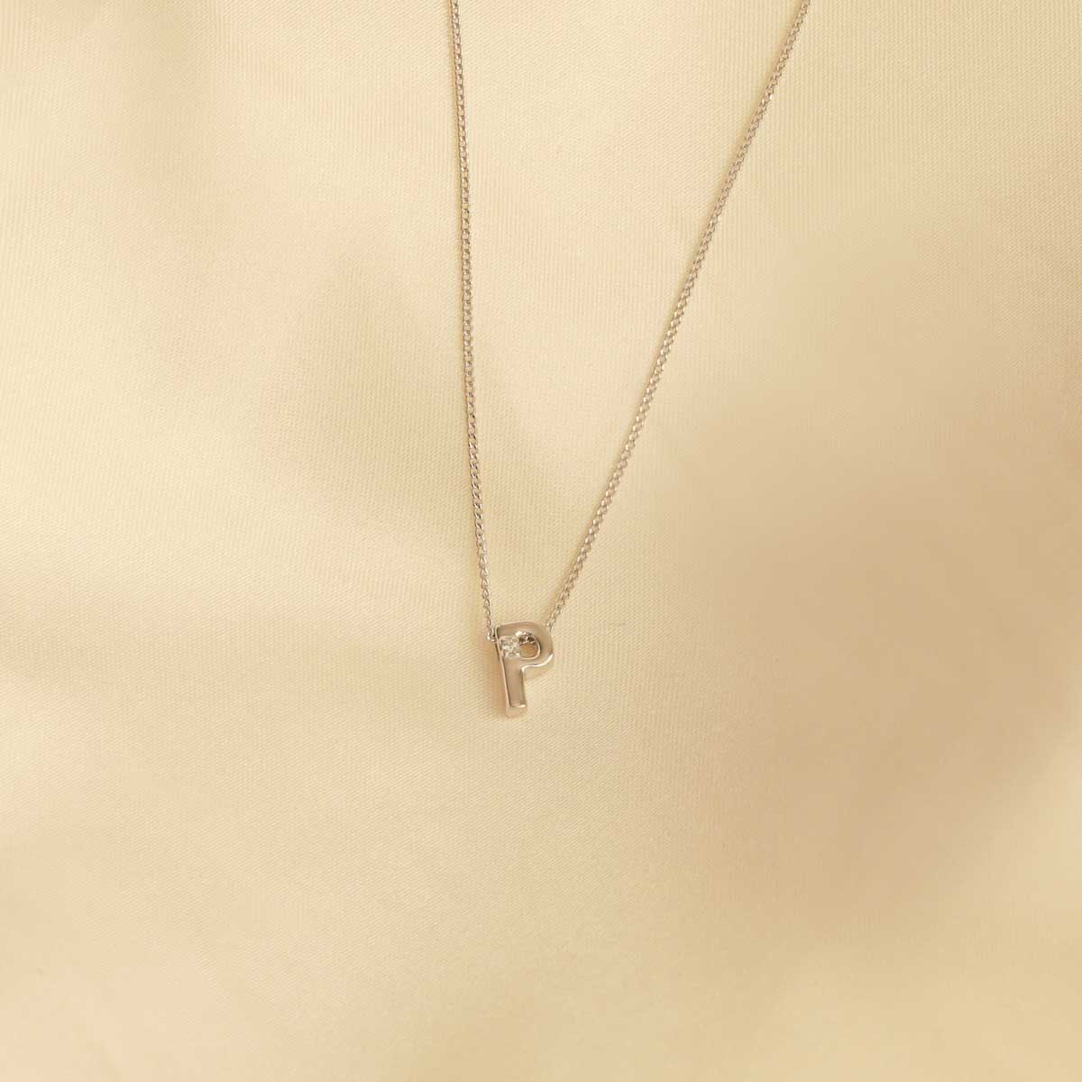 Flat lay shot of P Initial Pendant Necklace in Silver